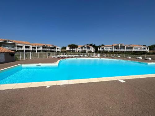 une grande piscine bleue dans un parking dans l'établissement Charmant appartement T2 pour 4 personnes vue mer sables d'olonne, à Saint-Jean-dʼOrbetiers