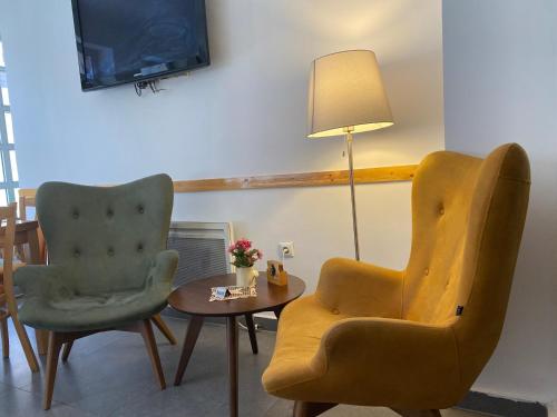 a living room with two chairs and a table and a tv at Hotel Berr in Sarajevo