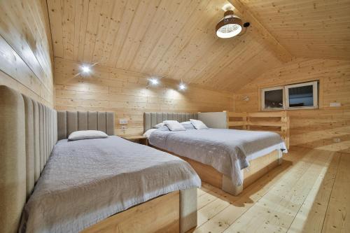 a bedroom with two beds in a wooden cabin at Apartament i Domek Komfort in Rabka-Zdrój