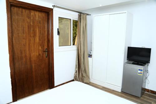 a room with a wooden door and a television at Lilly Rooms and Studio in Hurghada