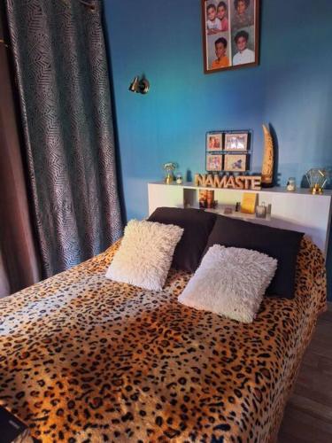 a bedroom with a leopard print bed with two pillows at Maison piscine à 15m du Stadium in Toulouse