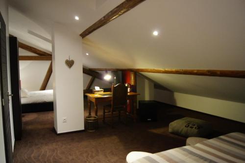 Zimmer mit einem Bett und einem Tisch in einem Zimmer in der Unterkunft Ferme Sainte Marie in Rémilly