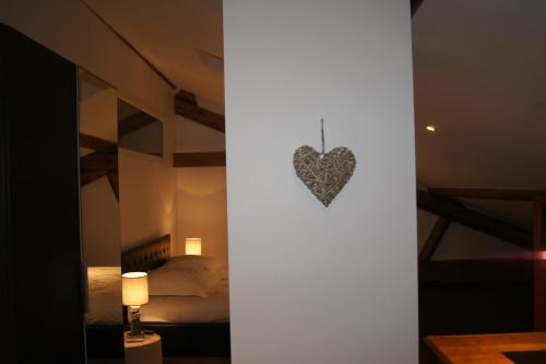 a heart hanging on a wall in a bedroom at Ferme Sainte Marie in Rémilly