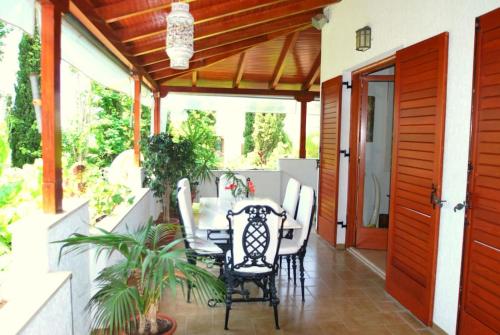 een patio met een tafel en stoelen op een veranda bij Fokiotripa (lovely villa on an enchanting beach) in Marathias