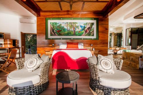 a room with a table with chairs and a tv on the wall at Villa Lala Boutique Hotel Adults Only in Puerto Vallarta