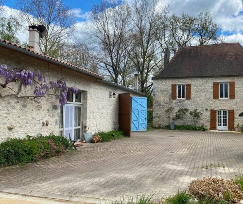 a white brick house with a blue door at Gîte la Grande Font in Saint-Capraise-dʼEymet