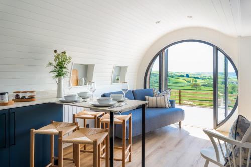 a kitchen and living room with a table and chairs at Ceunant in Aberystwyth