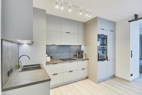 a kitchen with white cabinets and a sink at Apartamenty Świnoujście - Matejki 1b in Świnoujście
