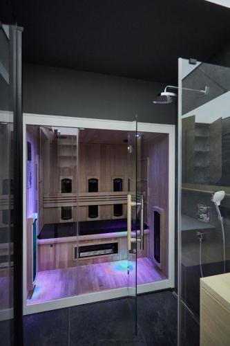 a bathroom with a glass shower with purple lighting at Apartamenty Świnoujście - Matejki 1b in Świnoujście