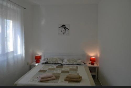 een slaapkamer met een bed met een klok aan de muur bij Apartment Lora in Pag