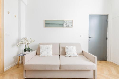 un salon blanc avec un canapé blanc dans l'établissement Appartement Moderne 1BR-4P - Guy Moquet, à Paris