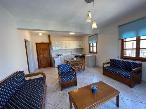 ein Wohnzimmer mit Sofas und einem Tisch sowie eine Küche in der Unterkunft Kavos Apartments Alonissos in Patitiri