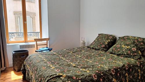 Au Fil de soi في مورليه: غرفة نوم مع سرير مع لحاف أخضر ونافذة