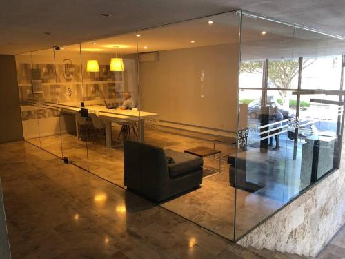 a living room with glass walls and a table and a couch at Studio GreenHaus - Pileta - Gym - Sauna in Buenos Aires