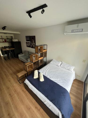 a bedroom with a bed and a living room at Studio GreenHaus - Pileta - Gym - Sauna in Buenos Aires