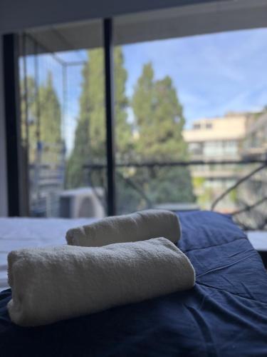 three folded towels sitting on top of a bed at Studio GreenHaus - Pileta - Gym - Sauna in Buenos Aires
