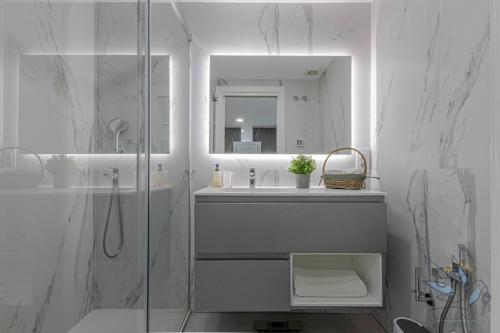 bagno con doccia, lavandino e specchio di Puerto Marina Luxury 2BDR Apartment with Sea View a Benalmádena
