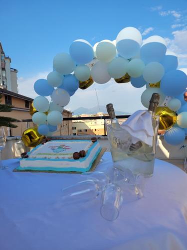 a table with a cake and a bunch of balloons at Palazzo Cappuccini Art Relais in Naples