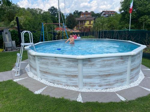 a man is in a pool in a yard at Villa Sofia in Baveno