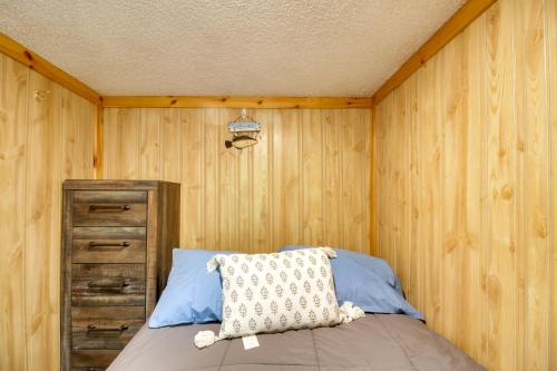 1 dormitorio con paredes de madera y 1 cama con almohada en Lakefront Cabin with Deck, Games, and Views!, 