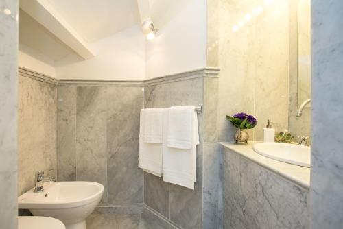 a bathroom with a white toilet and a sink at Appartamento La Torretta in Mondello
