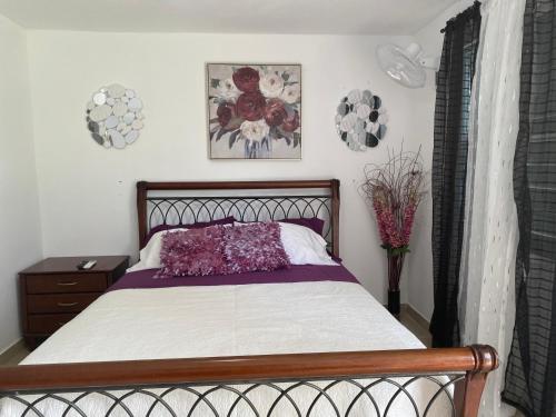 a bedroom with a bed with purple and white sheets at Gavidias Guest House in San Lorenzo