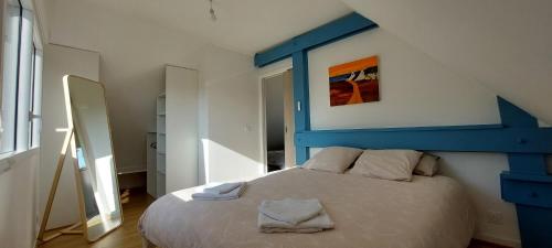 1 cama con cabecero azul en una habitación en Maison de vacances 4 Pers avec jardin privatif à 1km PLAGE Lines et 300m de la mer de Gâvres - AR PIL JADUR en Plouhinec