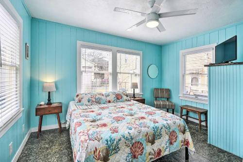 a blue bedroom with a bed and two windows at Historic Galveston Hideaway, Walk to the Beach! in Galveston