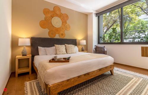 a bedroom with a large bed and a large window at Casa Taman by Kukun in Mexico City