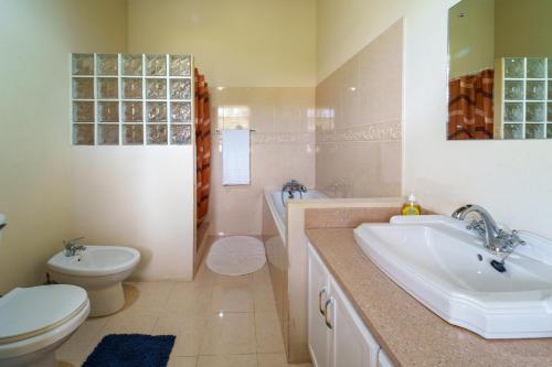 a bathroom with a sink and a toilet and a tub at Ferron House in Saint James