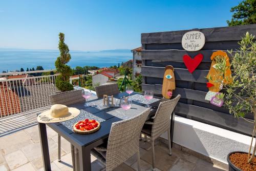 un tavolo e sedie su un balcone con vista sull'oceano di Apartment Mak a Opatija