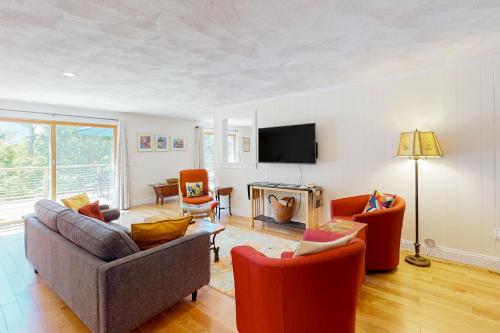 a living room with a couch and chairs and a television at Tall Pines in Wellfleet