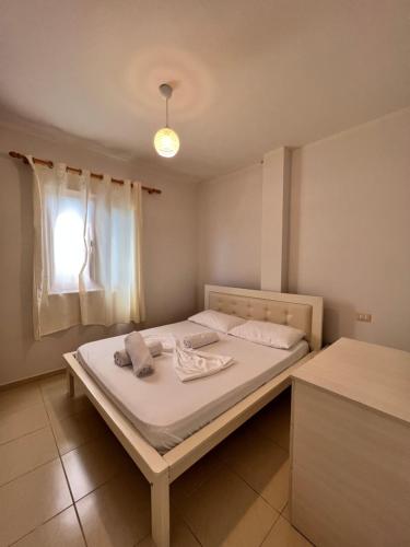 Bett in einem Zimmer mit Fenster in der Unterkunft Kamberi Hotel & Apartments in Velipojë
