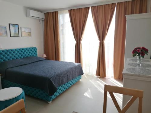 a bedroom with a blue bed and a large window at Kristi Lux Jezero - NEW Studio apartment with Balcony and FREE Parking in Veliko Gradište