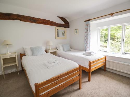 a bedroom with two beds and a window at Hall Bank Cottage in Rydal