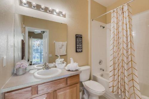 a bathroom with a sink and a toilet and a mirror at Disney Area Villa w/Pool Heat Included Featuring in Orlando