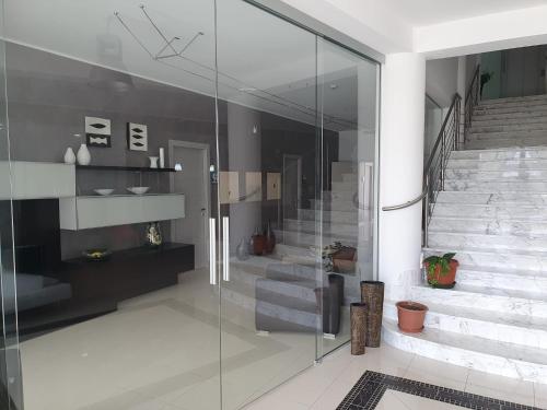 a glass staircase in a house with a glass wall at Villa Floyd Charming Rooms B&B in Pachino