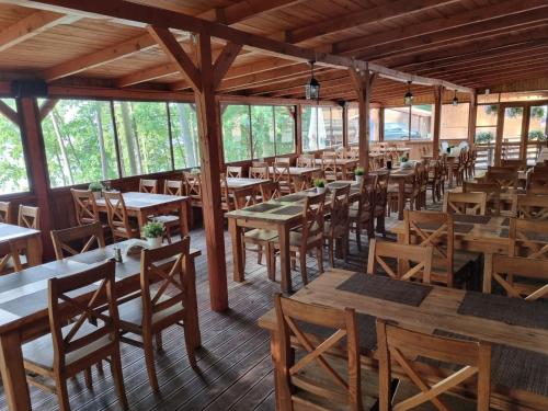 an empty restaurant with wooden tables and chairs at Ośrodek Wypoczynek Wodnik in Ruciane-Nida