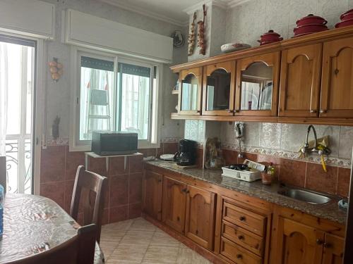 a kitchen with wooden cabinets and a table in it at Apartment soultana in Tangier