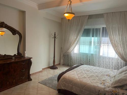 a bedroom with a bed and a window and a dresser at Apartment soultana in Tangier