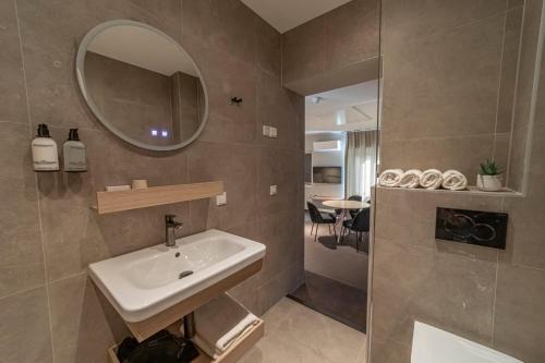 a bathroom with a sink and a mirror and a shower at Strandstudio's Camperduin in Schoorl