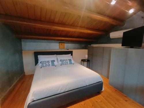 a bedroom with a white bed and a tv at Numero VENTI in Montefiascone
