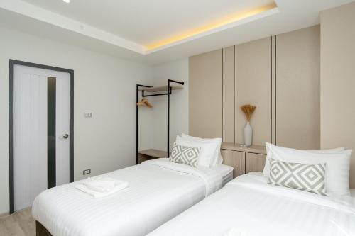 two beds sitting next to each other in a bedroom at The Riski Hotel at Bangphlat Station SHA in Bangkok
