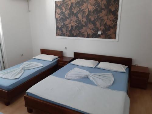 Duas camas individuais num quarto com uma fotografia na parede em Kalajdzic em Igalo