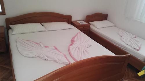 two twin beds in a room with white sheets at Kalajdzic in Igalo