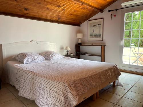 - une chambre avec un grand lit et un plafond en bois dans l'établissement Chambre d'hôtes en duplex du petit mas niçois, à Nice