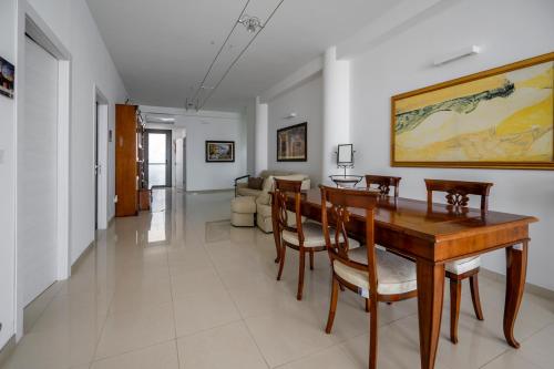 a dining room with a wooden table and chairs at Villa Floyd Charming Rooms B&B in Pachino