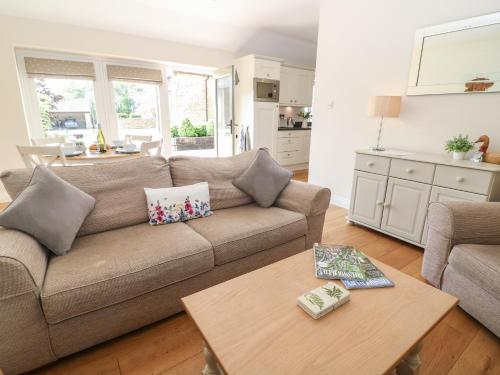 a living room with a couch and a table at Ewecub Barn in Burford