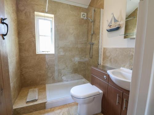 a bathroom with a toilet and a sink at Saddlebacks Barn in Burford