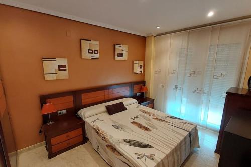 Un dormitorio con una cama grande y una ventana en Apartamento en urbanización lujo en Tavernes de Valldigna
